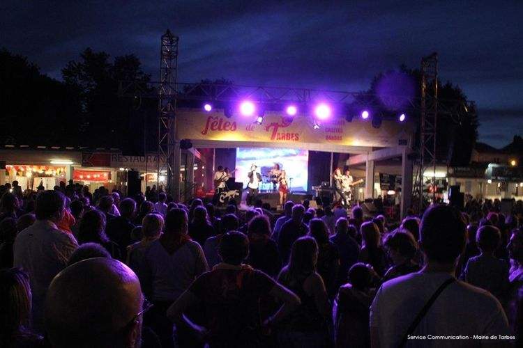 Des personnes rassemblées devant la scène pour assister à un concert des fêtes de Tarbes durant la nuit